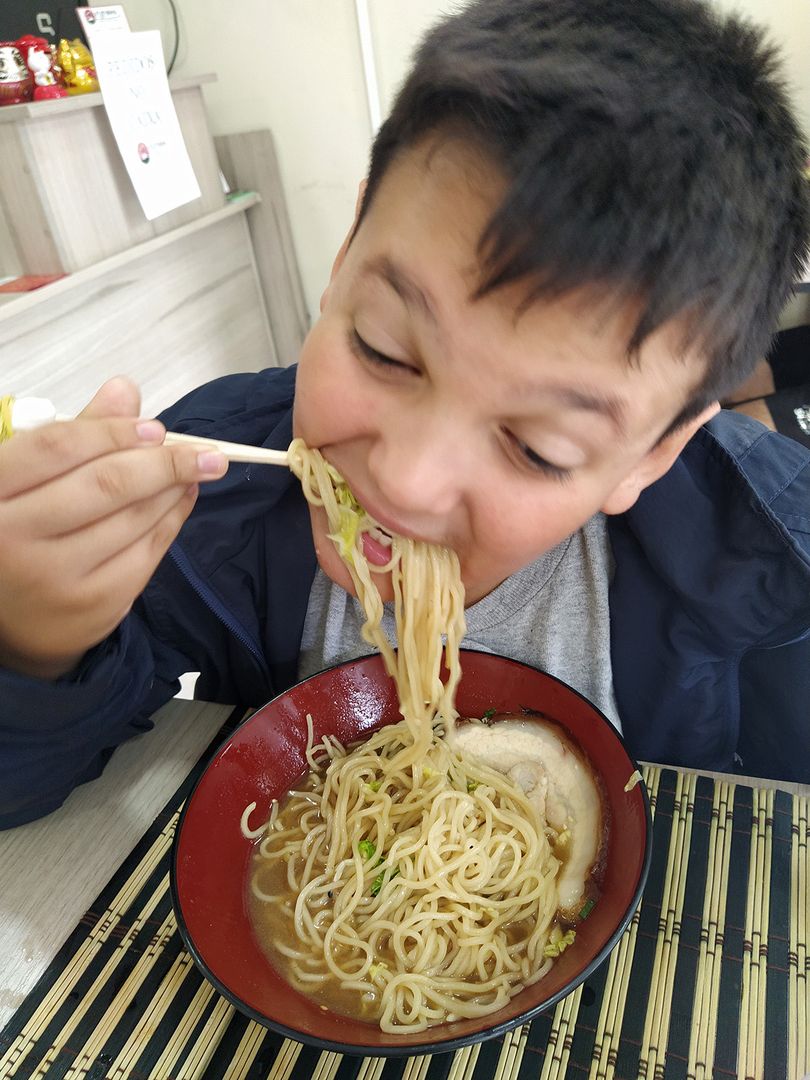 Davi eating ramen with chopsticks